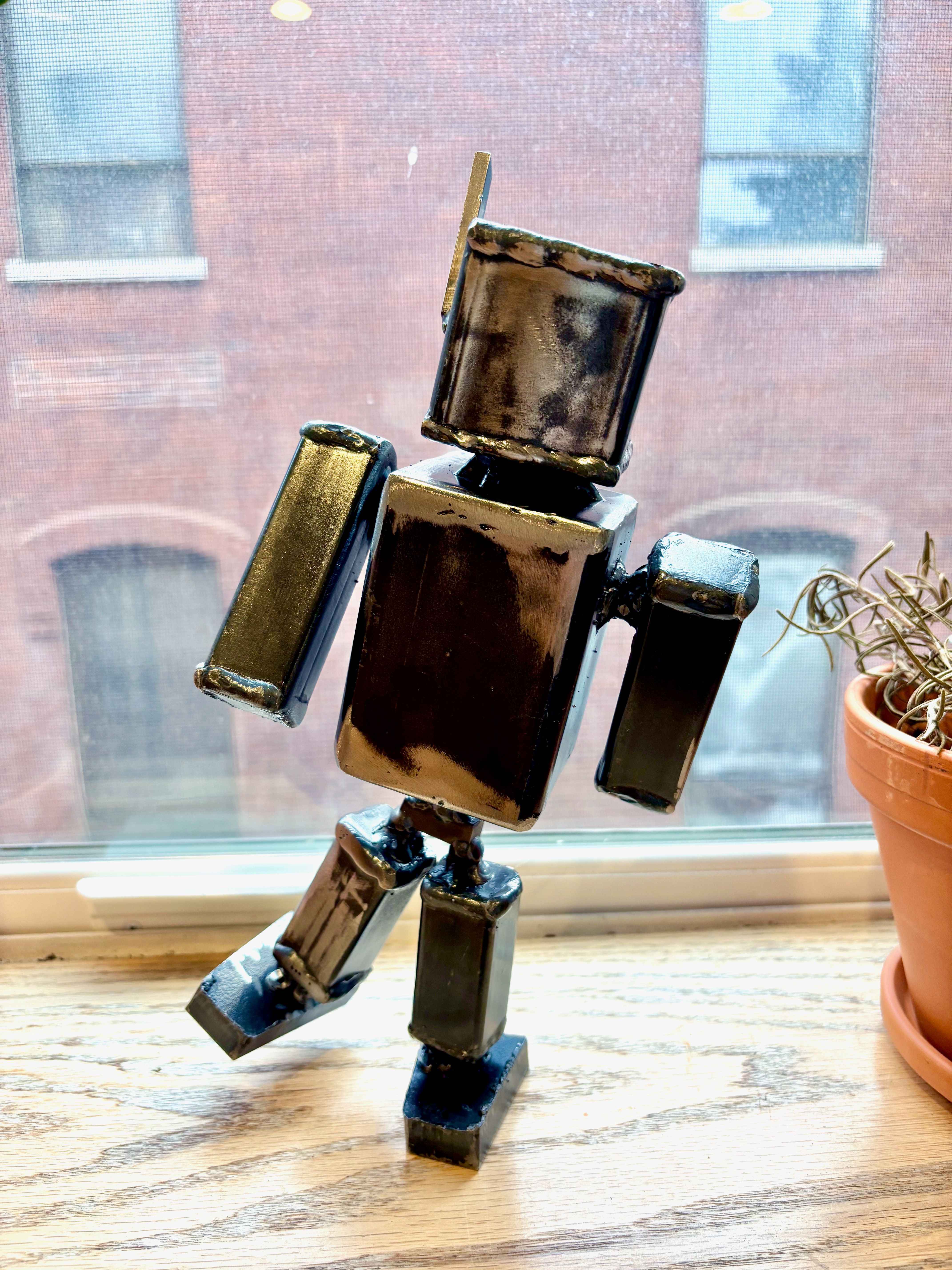 Robot sculpture on window sill.