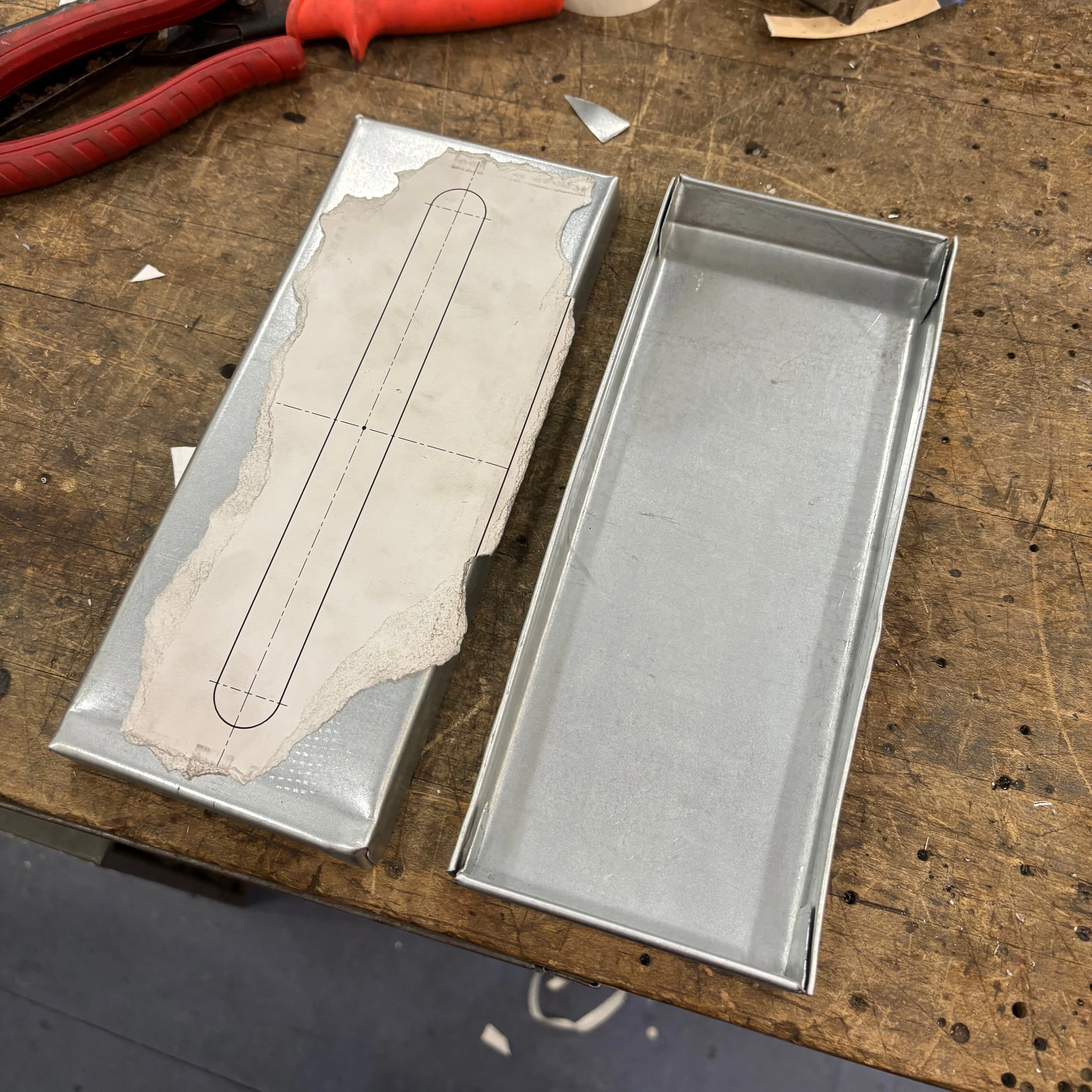 Completely folded top and bottom pieces of the sheet metal tissue box
